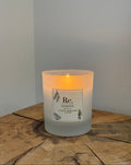 Candle with a label on a wooden surface and light gray background