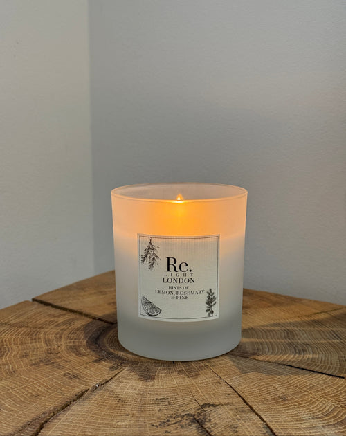 Candle with a label on a wooden surface and light gray background