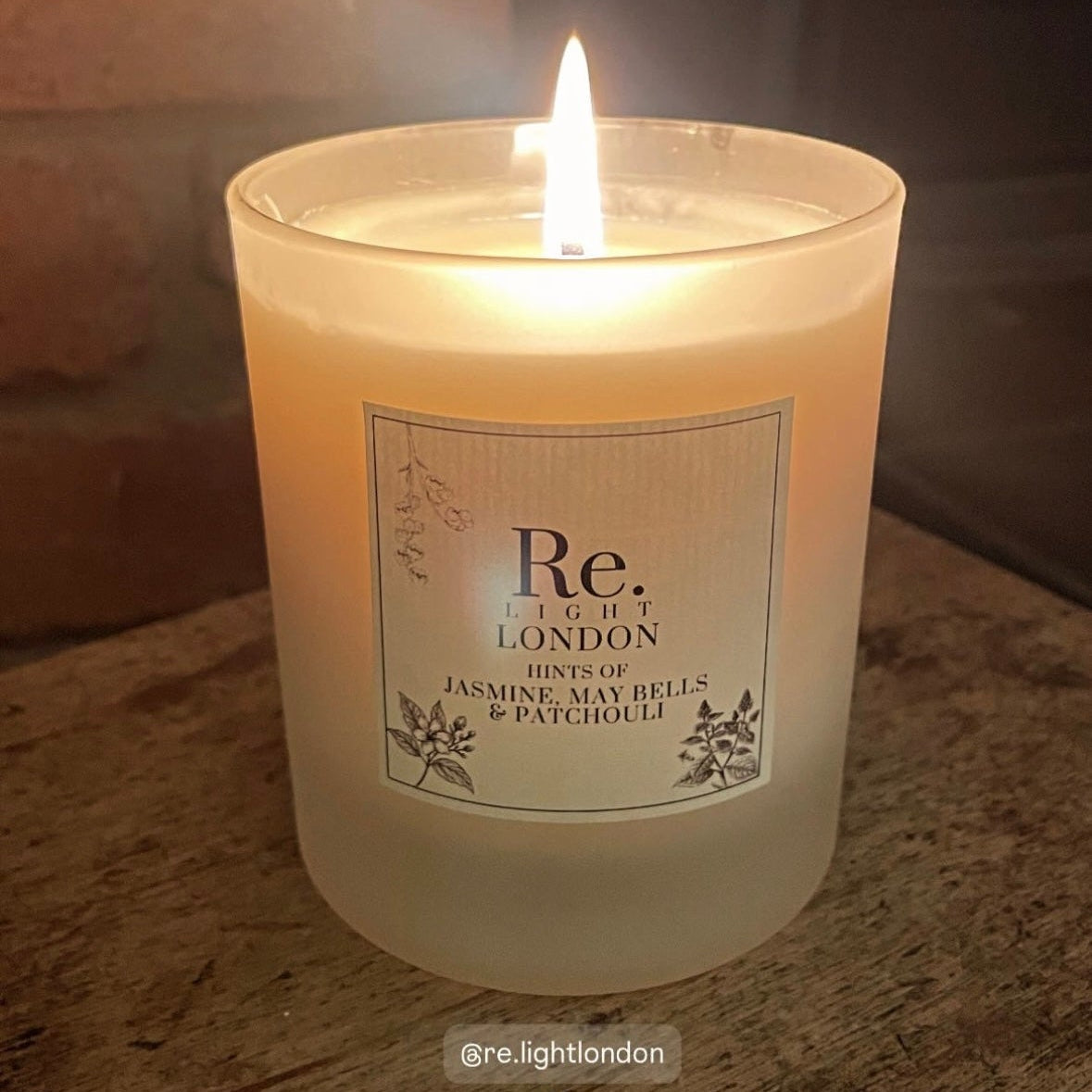 Candle with a label on a wooden surface, featuring the brand 'Re.Light London'.