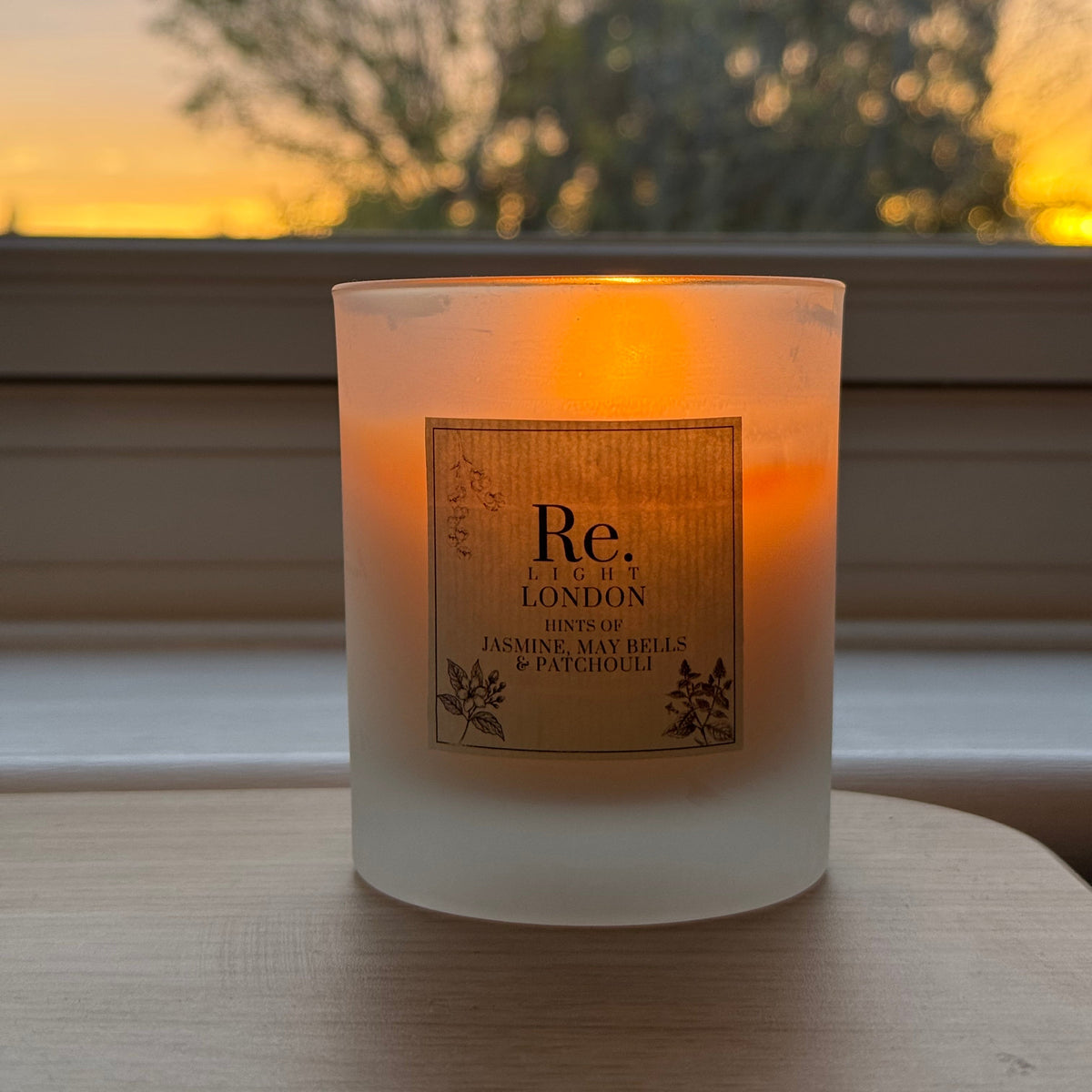 Re. Candle (Jazz) with a label on a window sill, blurred outdoor background